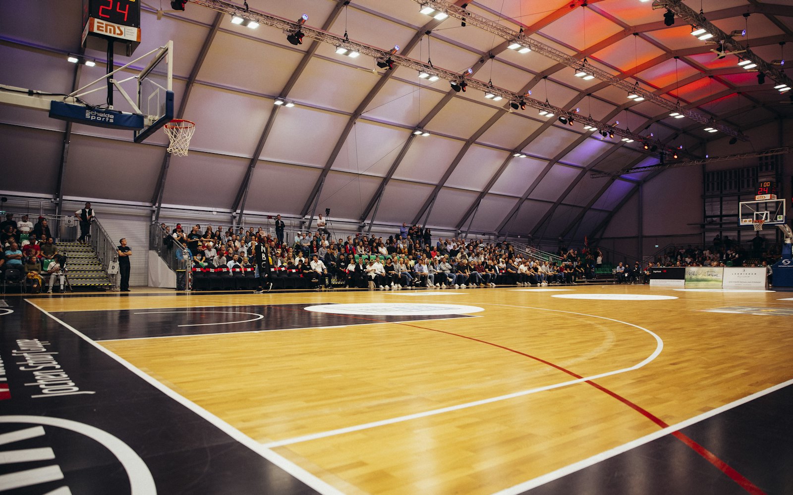 Players on the wooden court of the Pinecrest Recreation Center gymnasium during a game.